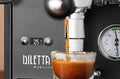Diletta Bello+ espresso machine front panel with brew pressure gauge as espresso pours into a glass