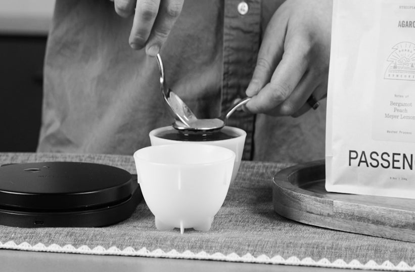Person brewing pour over coffee outdoors using an AeroPress, with a bag of Passenger Coffee nearby - Seattle Coffee Gear