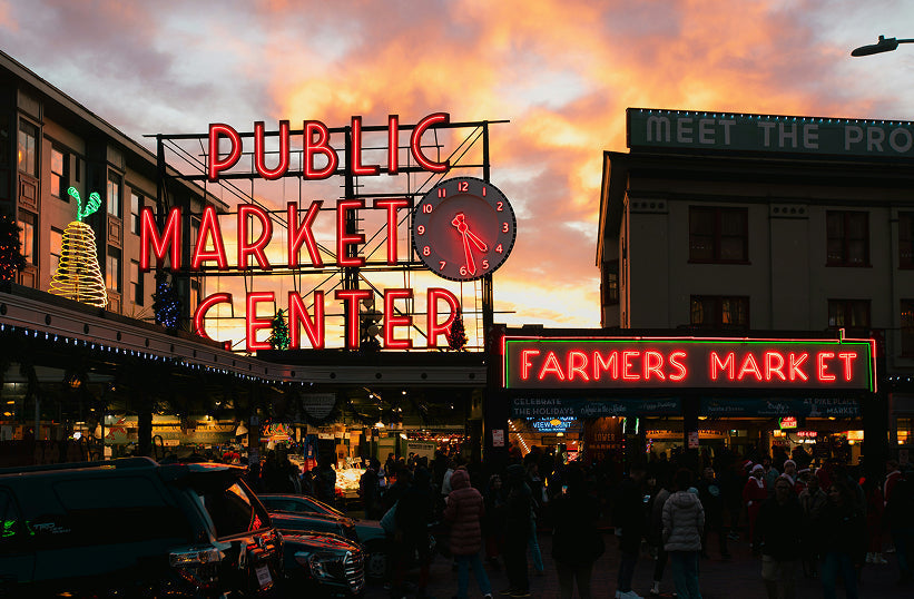 Pike Place Market neon sign glowing at sunset in downtown Seattle